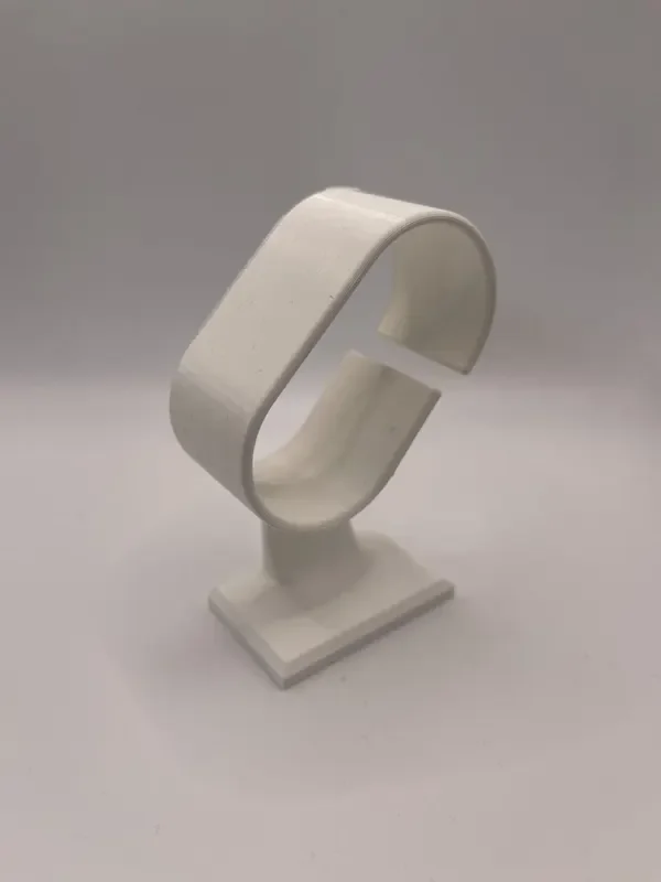 Witte 3D-geprinte horlogehouder met open band op een voet